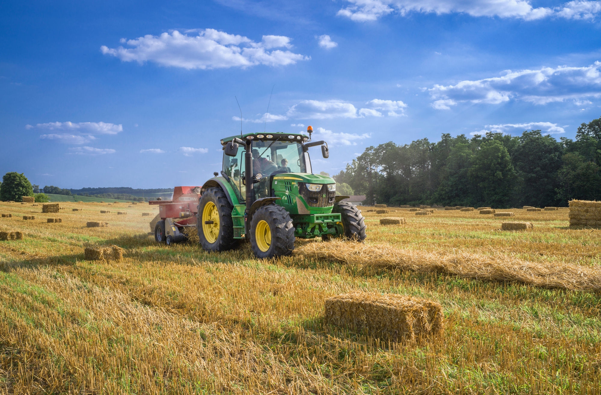 Tractor baling straw at harvest
